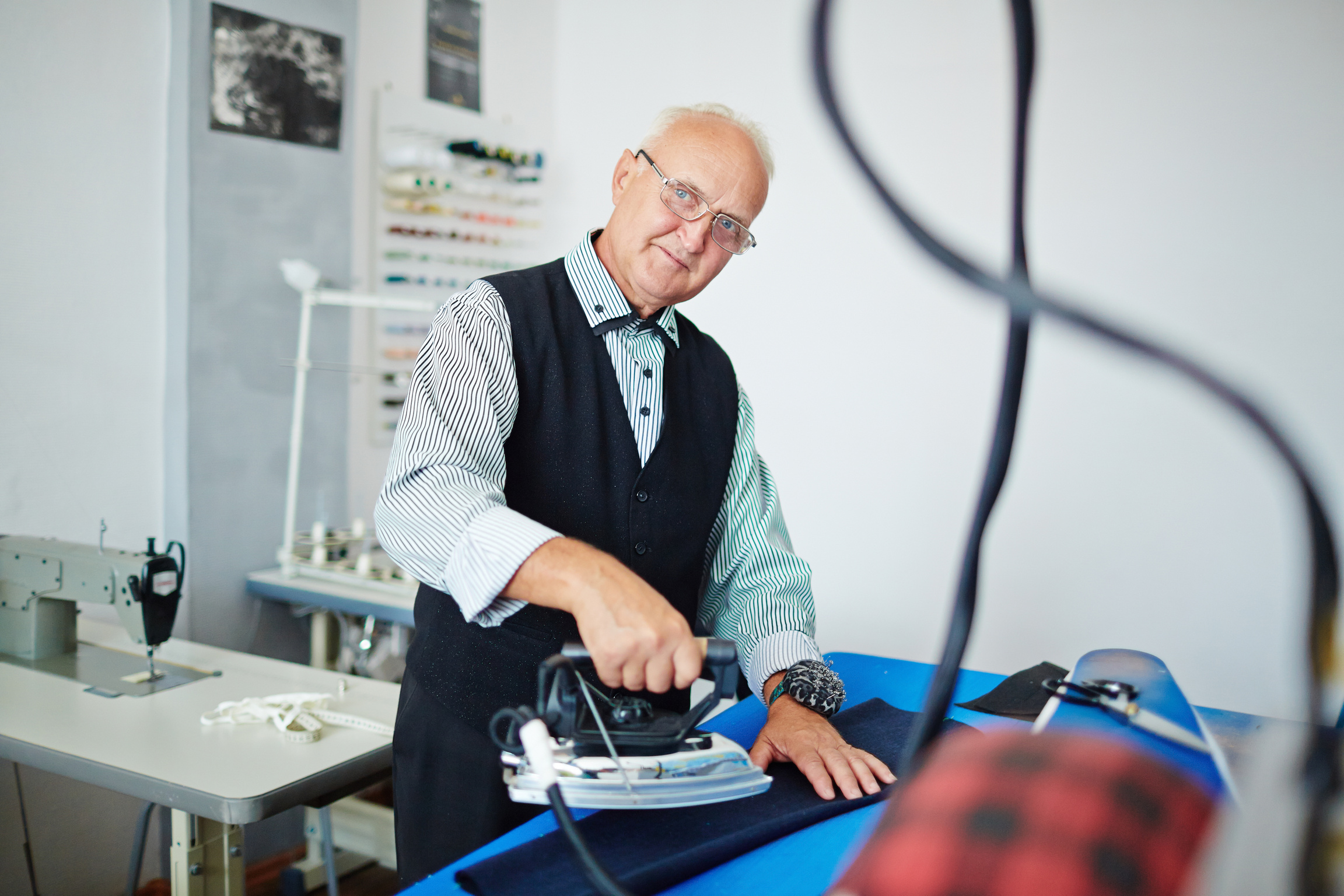 Old Fashioned Tailor Ironing in Atelier